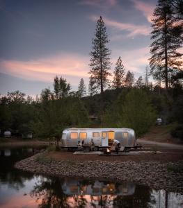 米德派恩斯AutoCamp Yosemite的停在水体旁边的银色拖车