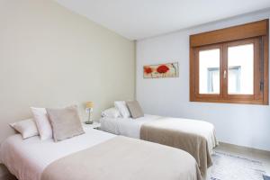 圣克鲁斯-德特内里费Céntrico y con Vistas Santa Cruz, Vacation Home的白色客房的两张床,设有窗户
