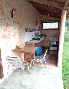 圣若热岛Chalés Ocaso的厨房配有木桌和两把椅子