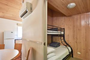 巴瑟斯特NRMA巴瑟斯特全景假日公园的小房间设有双层床和桌子