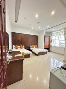 Ðưc TrọngHoàng Anh hotel的酒店客房配有两张床和一张书桌