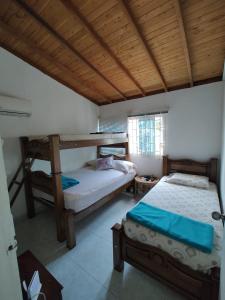 TubaráDON SEBAS y SUS DOS MARIAS的一间卧室设有两张双层床和木制天花板。