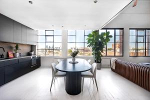 墨尔本New York Converted Warehouse Apartment in Richmond的厨房以及带桌椅的用餐室。