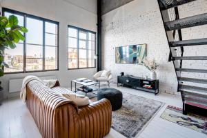 墨尔本New York Converted Warehouse Apartment in Richmond的带沙发和电视的客厅