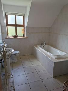莱特肯尼Comfortably Crolly Holiday Home的白色的浴室设有浴缸和卫生间。