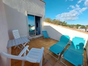 马瑟伊兰Appartement Marseillan-Plage, 2 pièces, 5 personnes - FR-1-326-777的阳台配有桌椅和桌子。