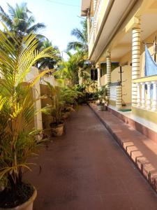 帕罗林Regina Residency Inn的棕榈树和植物的建筑走廊