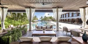 加弗阿利夫环礁马尔代夫柏悦酒店的一个带桌椅的户外庭院和一个游泳池