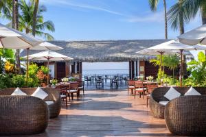 额布里湾景 - 海滩度假村的室外餐厅设有桌椅和遮阳伞。