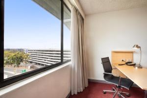 墨尔本墨尔本机场假日酒店的一个带书桌和大窗户的办公室