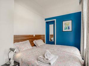 哈利法克斯Crossley Suite - Uk38334的一间卧室设有蓝色的墙壁和一张带毛巾的床。