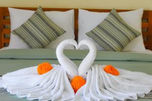 珀尼达岛Maja House Penida的床上用毛巾制成的两天鹅