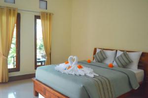 珀尼达岛Maja House Penida的一间卧室,配有一张带鲜花的床