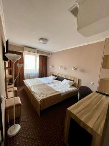 比什凯克Seven Hotel Bishkek的配有一张床和一张书桌的酒店客房