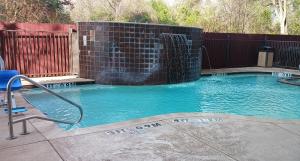 朗维尤Red Roof Inn & Suites Longview的一座小型游泳池,设有瀑布