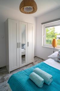 加茨比亚格拉Turkusowy Klif的一间卧室配有一张带蓝色床单的床和一扇窗户。