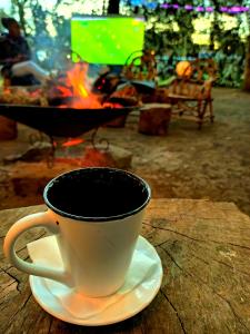 纳纽基Riverside Villas Nanyuki的 ⁇ 火旁的碟子上坐着咖啡杯