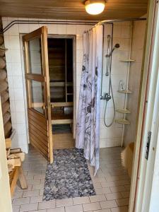 UlvilaElämyksellinen huvila Tuurujärven rannalla.的带淋浴和浴帘的浴室