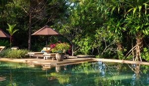 乌纳瓦图纳Why House的一个带桌椅和遮阳伞的游泳池