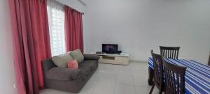 Bandar Puncak AlamHud Hud Homestay的带沙发和电视的客厅