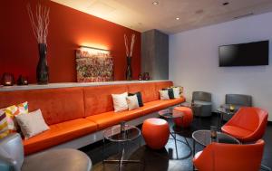 杜塞尔多夫杜塞尔多夫市中心温德姆花园国王大道酒店的大堂设有橙色沙发和橙色椅子