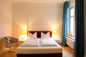 汉堡施拉夫朗奇酒店的卧室配有床、椅子和窗户。