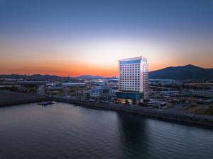 光阳光阳吉祥酒店的一条高大的建筑,毗邻一条有日落的河流