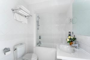 巴黎柯马丁歌剧院阿斯托利亚酒店的白色的浴室设有卫生间和水槽。