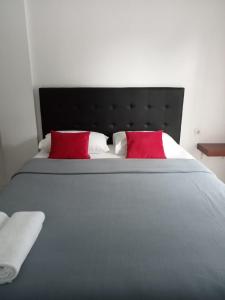 纳闽巴霍Guest House d Valeri的一张大床,上面有两个红色的枕头