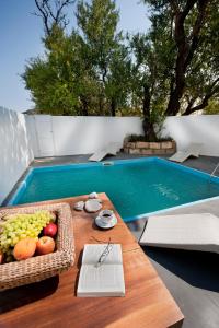 斯基罗斯岛内菲利酒店的一张桌子,旁边是游泳池,上面有一篮水果