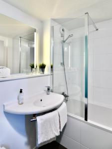 瓦讷瓦纳宜必思快捷酒店的白色的浴室设有水槽和淋浴。