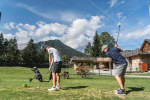克拉尼斯卡戈拉Sport & Sunny Cosy Alpine Retreat的两个男人和狗一起打高尔夫