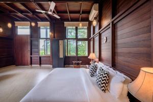 加尔利SaffronStays Boulevard LogHouse - a wooden chalet amidst nature的一间带一张大床的卧室,位于带木墙的房间
