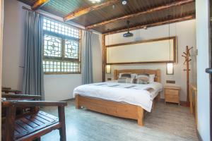 南靖县南靖土楼鑫源民宿的一间卧室设有一张床和一个大窗户