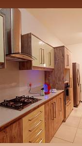 弗利康弗拉克WESTWOOD - DELUXE 03 BEDROOM APPARTMENT - POOL, near BEACH的厨房配有木制橱柜和炉灶烤箱。