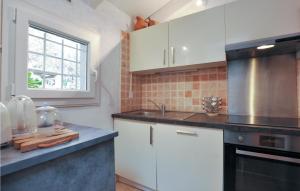 拉戈德Beautiful Apartment In La Gaude With Kitchenette的厨房配有白色橱柜、水槽和窗户。