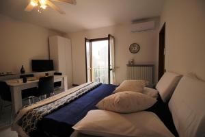BarzanaCasa Vacanze Doralice的一间卧室配有一张床、一张书桌和一个窗户。