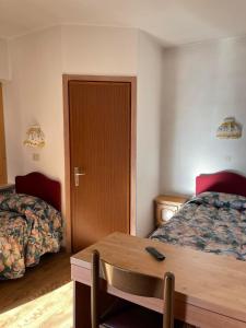 马津瑟西里亚别墅酒店的酒店客房设有两张床和一张木桌。