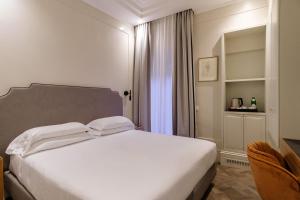 罗马绿宝石酒店的卧室配有白色的床和椅子
