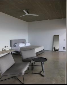 KástronEchoes Exclusive Suite的一间卧室配有一张床、两把椅子和一张桌子