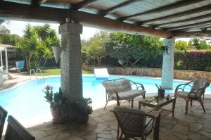 巴里萨尔多Villa Lanthana, 2 storeys, detached的一个带椅子的庭院和一个游泳池