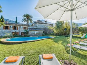 波连斯萨Villa Can Fanals by SunVillas Mallorca的一个带椅子和遮阳伞的游泳池以及一间房屋