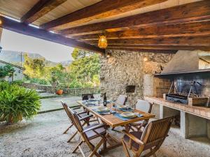 波连斯萨Villa Can Fanals by SunVillas Mallorca的庭院配有木桌和椅子,设有炉灶