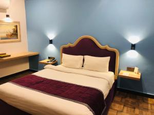 拉合尔Hotel Oban的一间卧室设有一张蓝色墙壁的大床