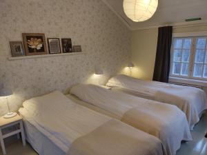 JomalaBrobacka Gästhem的卧室内的两张床,配有两盏灯和一扇窗户
