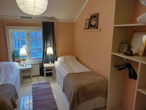 JomalaBrobacka Gästhem的一间卧室设有两张床、一张桌子和一个窗口。