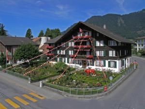 因特拉肯瑞士小屋酒店的一座大建筑,前面设有花园