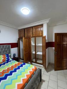 雅温得Appartement New Stading YAOUNDE - MIMBOMAN MAETURE的一间卧室配有一张床和一些木橱柜。