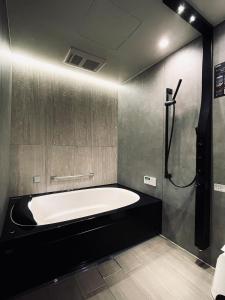 金泽兼六坂酒店的一间带大浴缸和淋浴的浴室