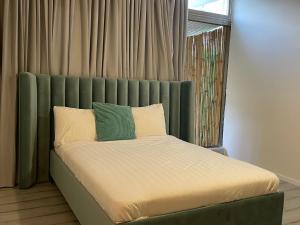 佩塔提克瓦Rothschild 79的一张带绿色床头板的床